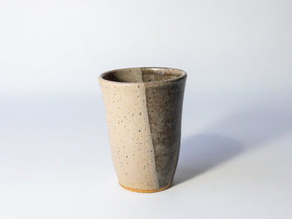Two-toned ceramic cup on a light gray background